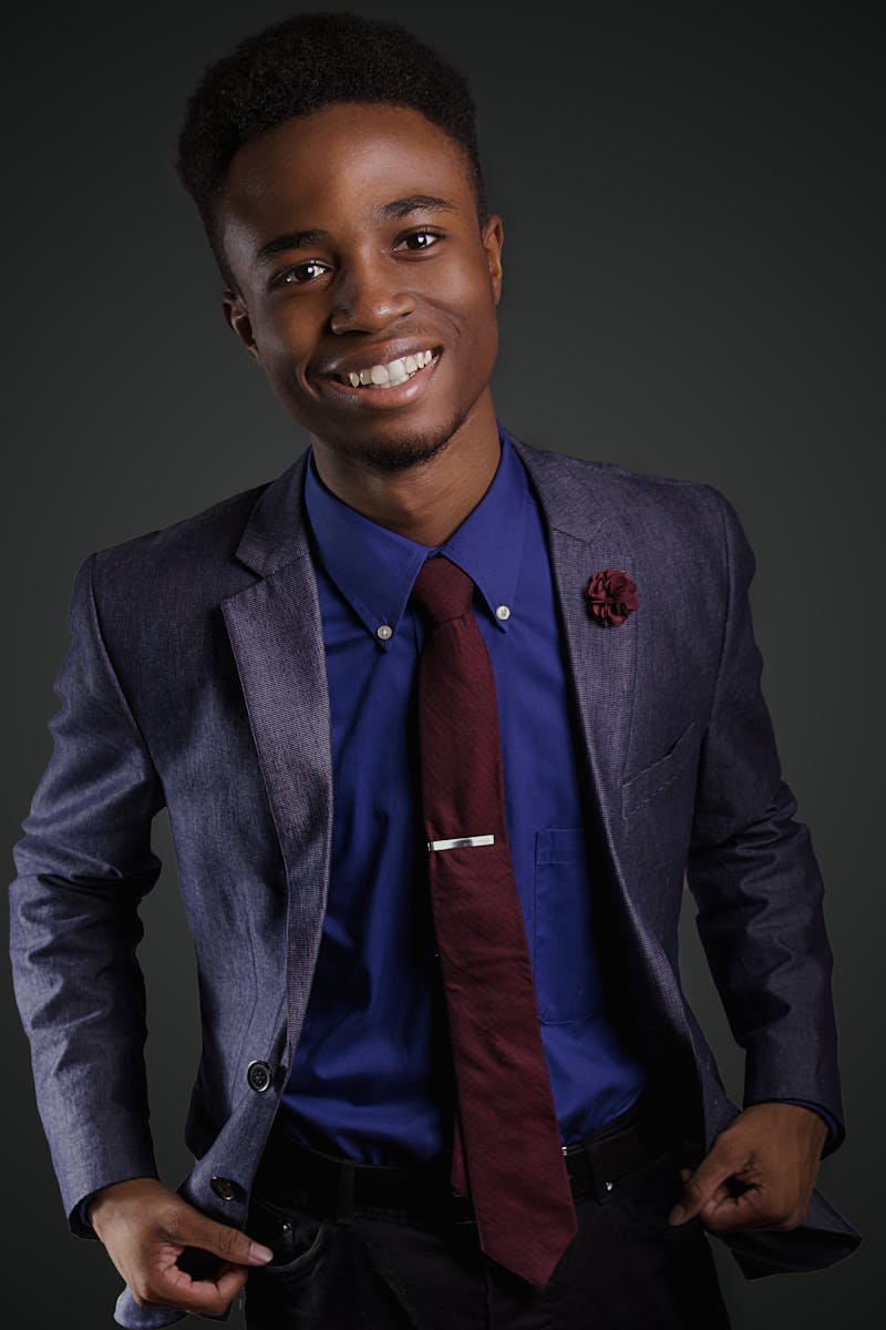 Portrait of a smiling young black man in a stylish suit with a confident pose.